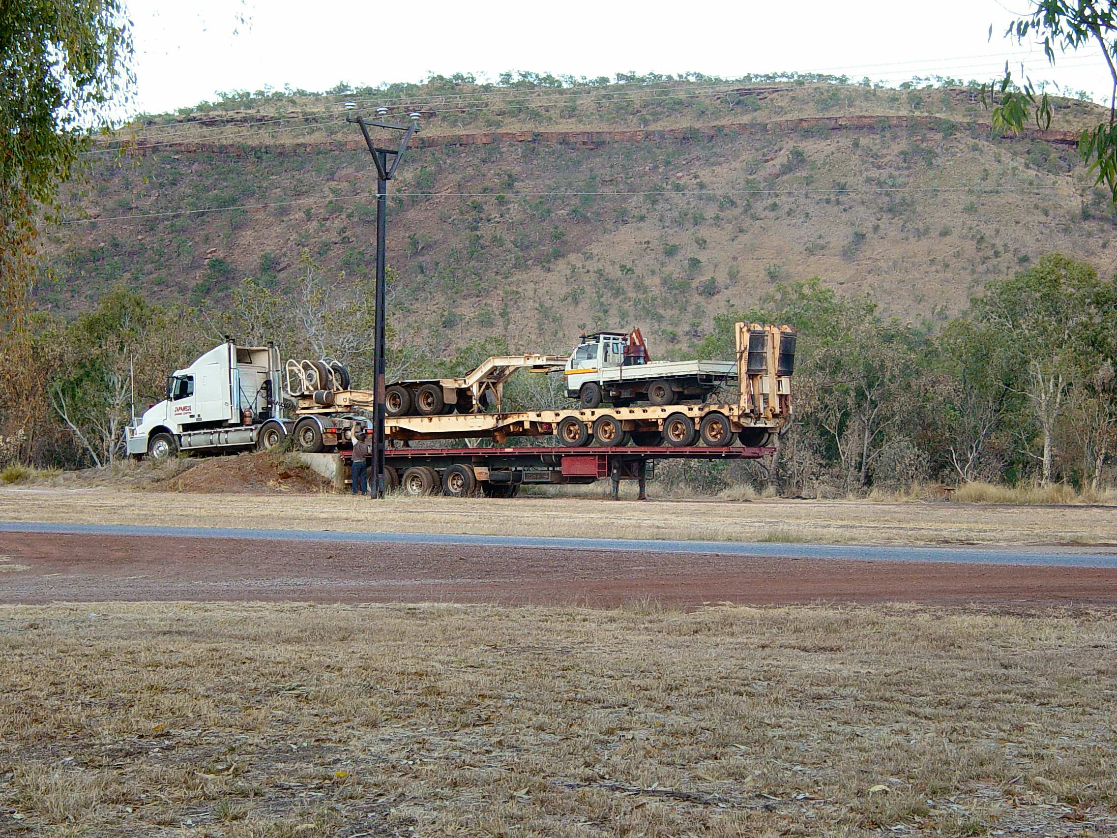 Flatbed trailer loaded with construction materials on highway, illustrating spot rate movement in trucking freight markets