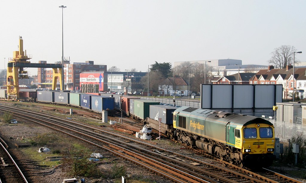 Wabtec locomotive on rail yard tracks with freight cars in background
