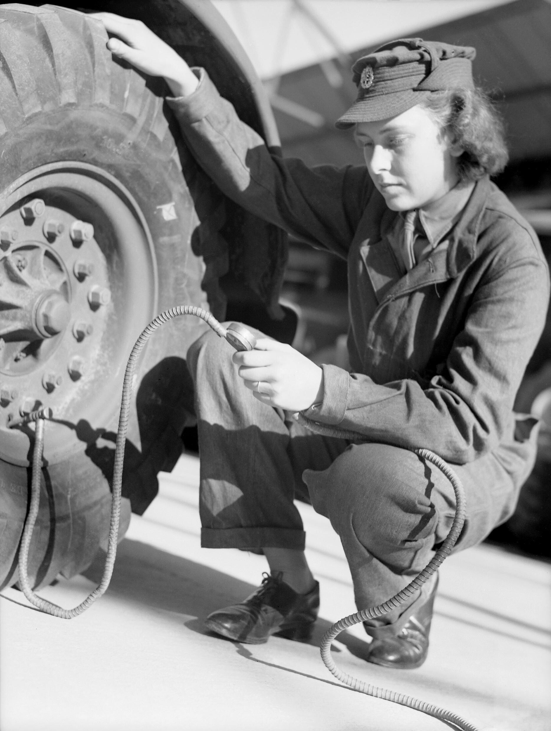 Truck driver instructor reviewing pre-trip inspection checklist with trainee beside commercial vehicle