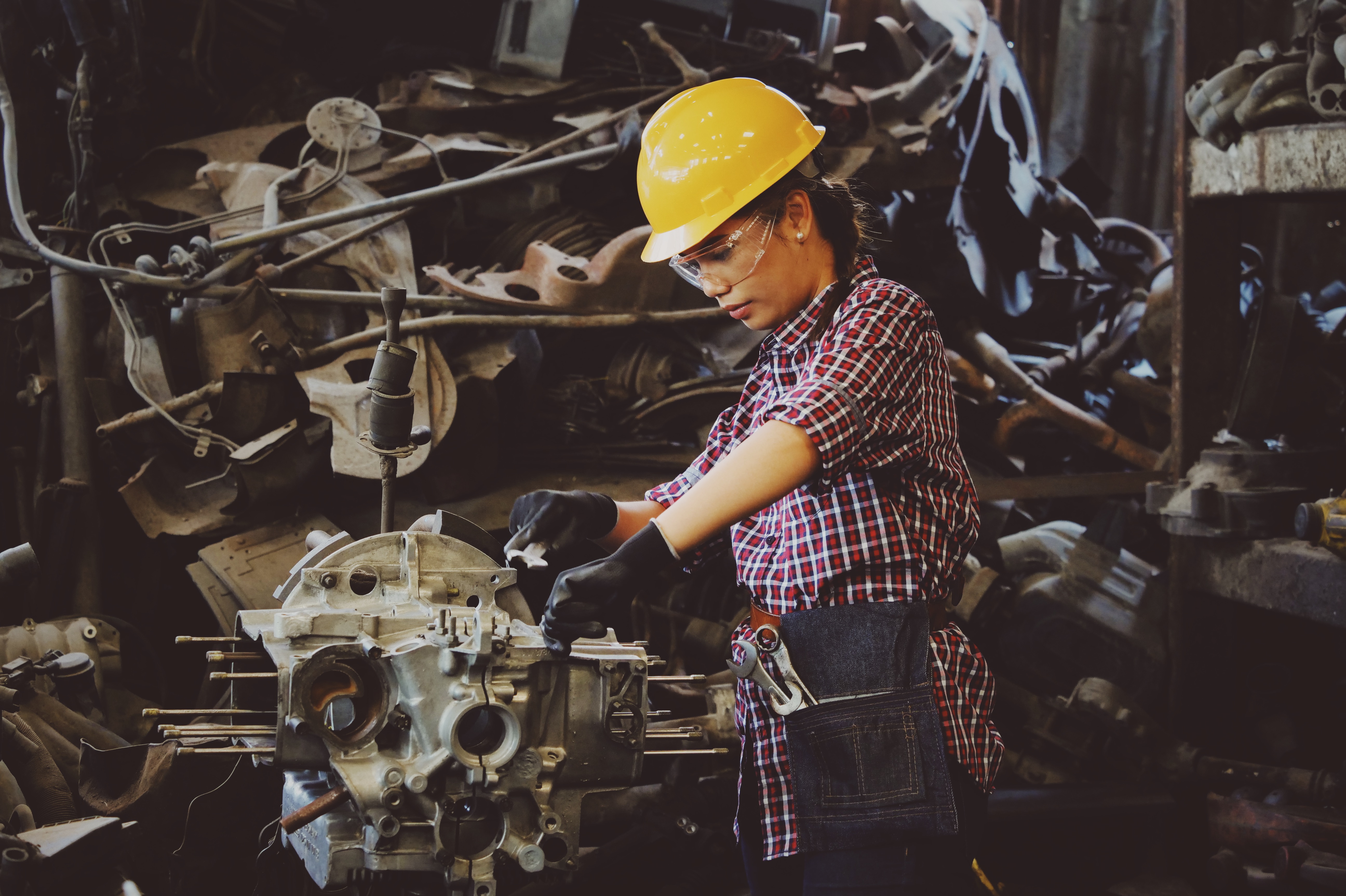 Semi-truck undergoing maintenance in a fleet repair shop with technician inspecting undercarriage