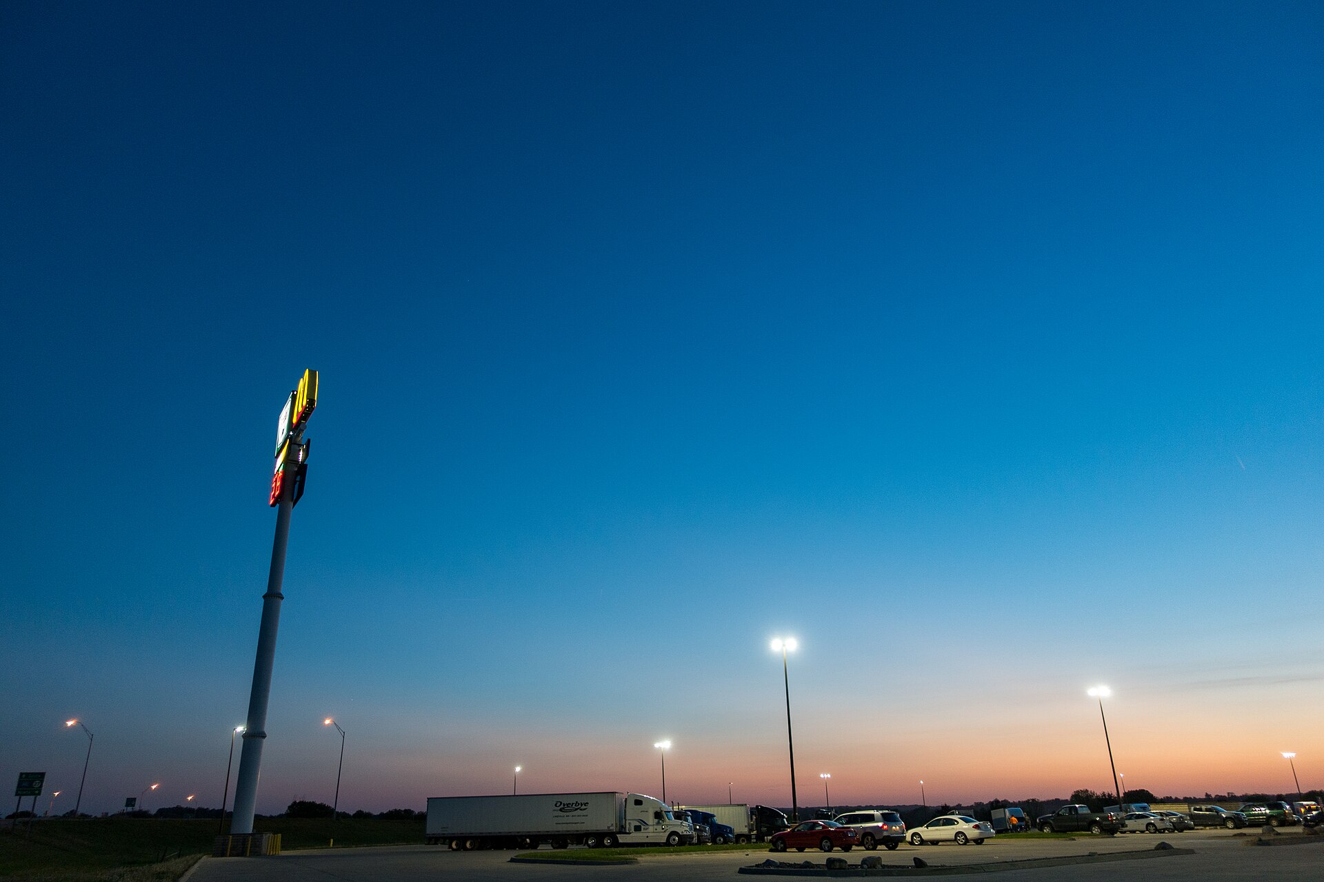 Empty truck parking spaces at a rest area along an interstate highway at dusk