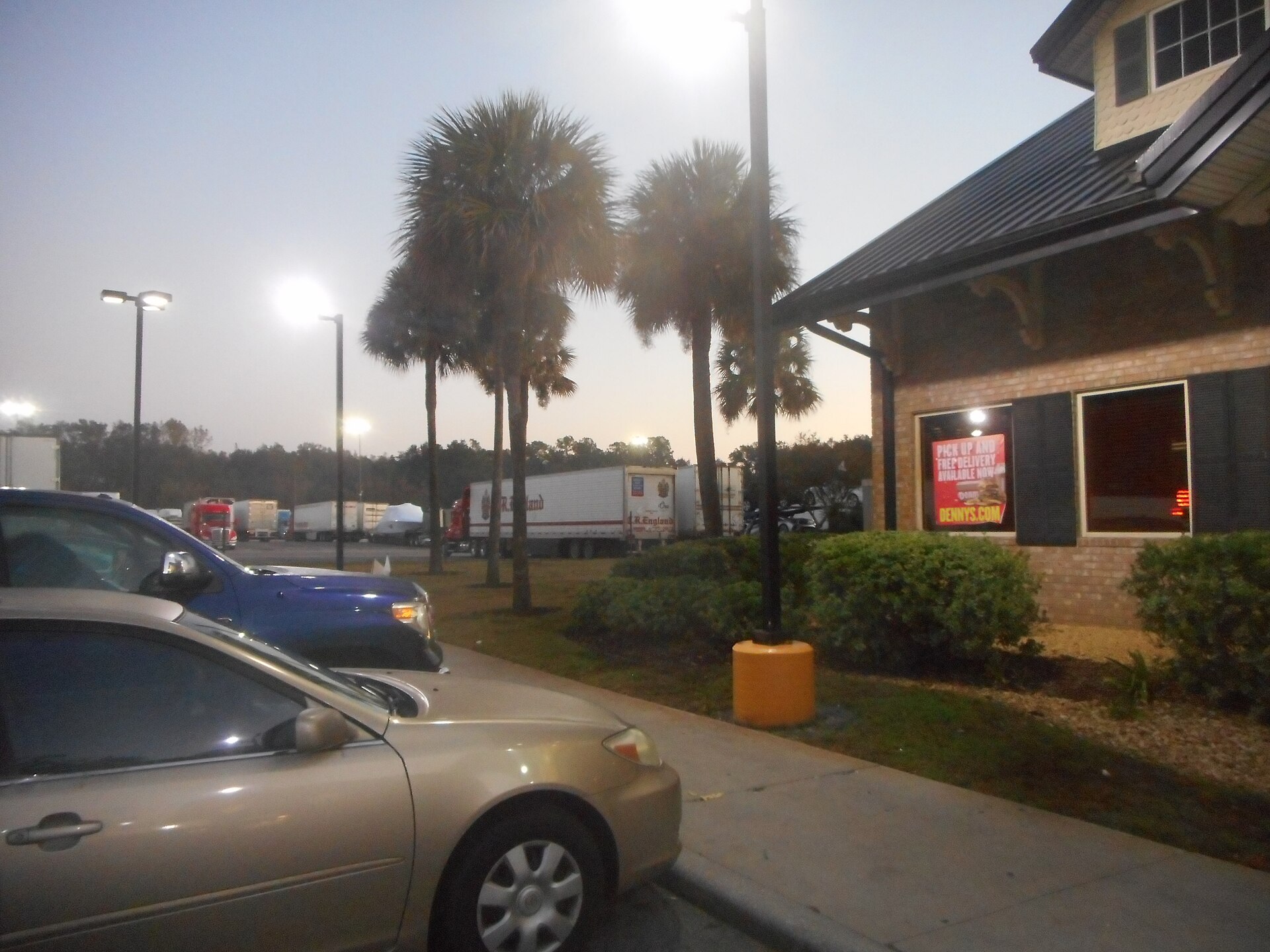 Ryder semi-tractor on dealer lot with used truck inventory in background