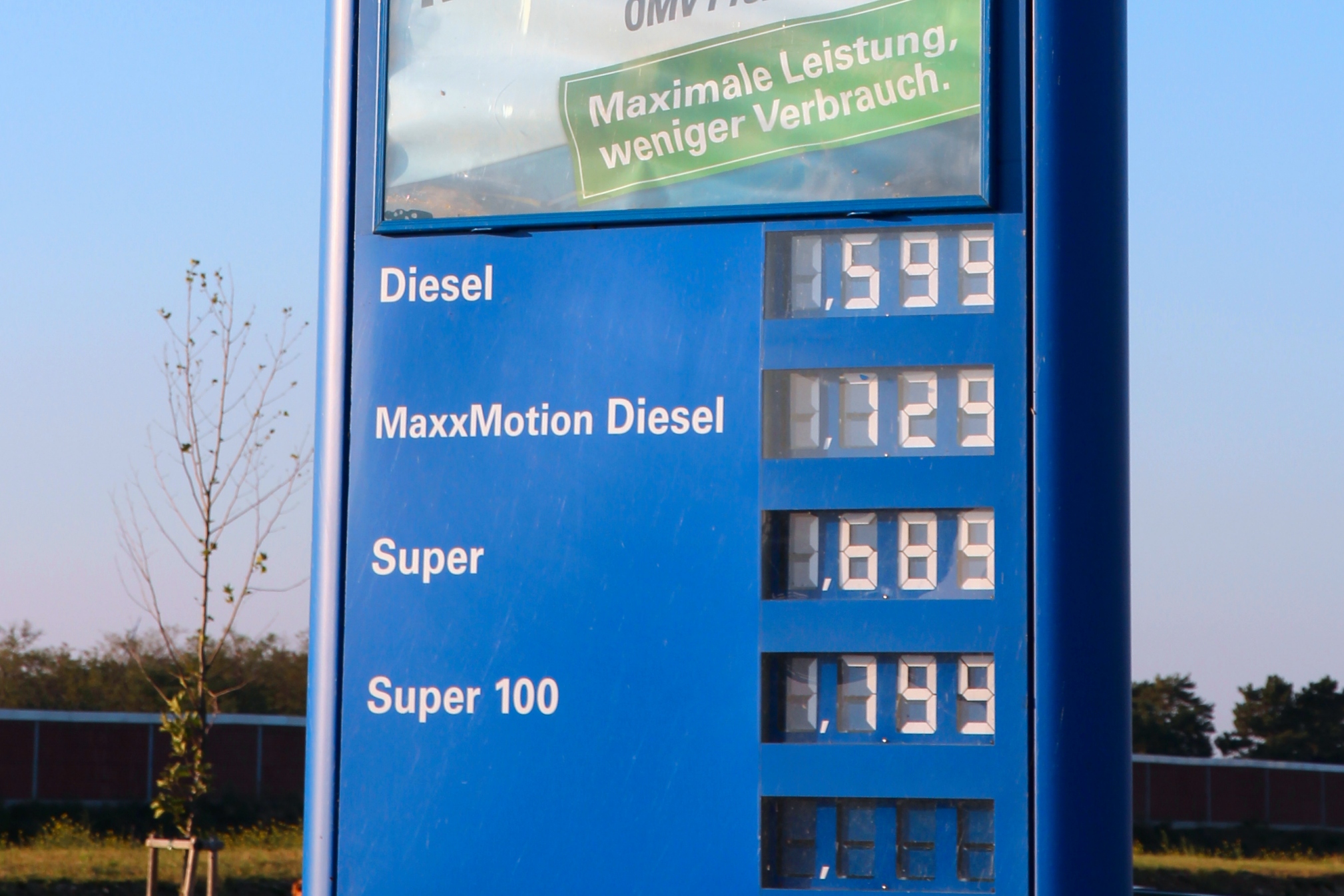 Diesel fuel pump nozzle at truck stop with price display showing rising fuel costs