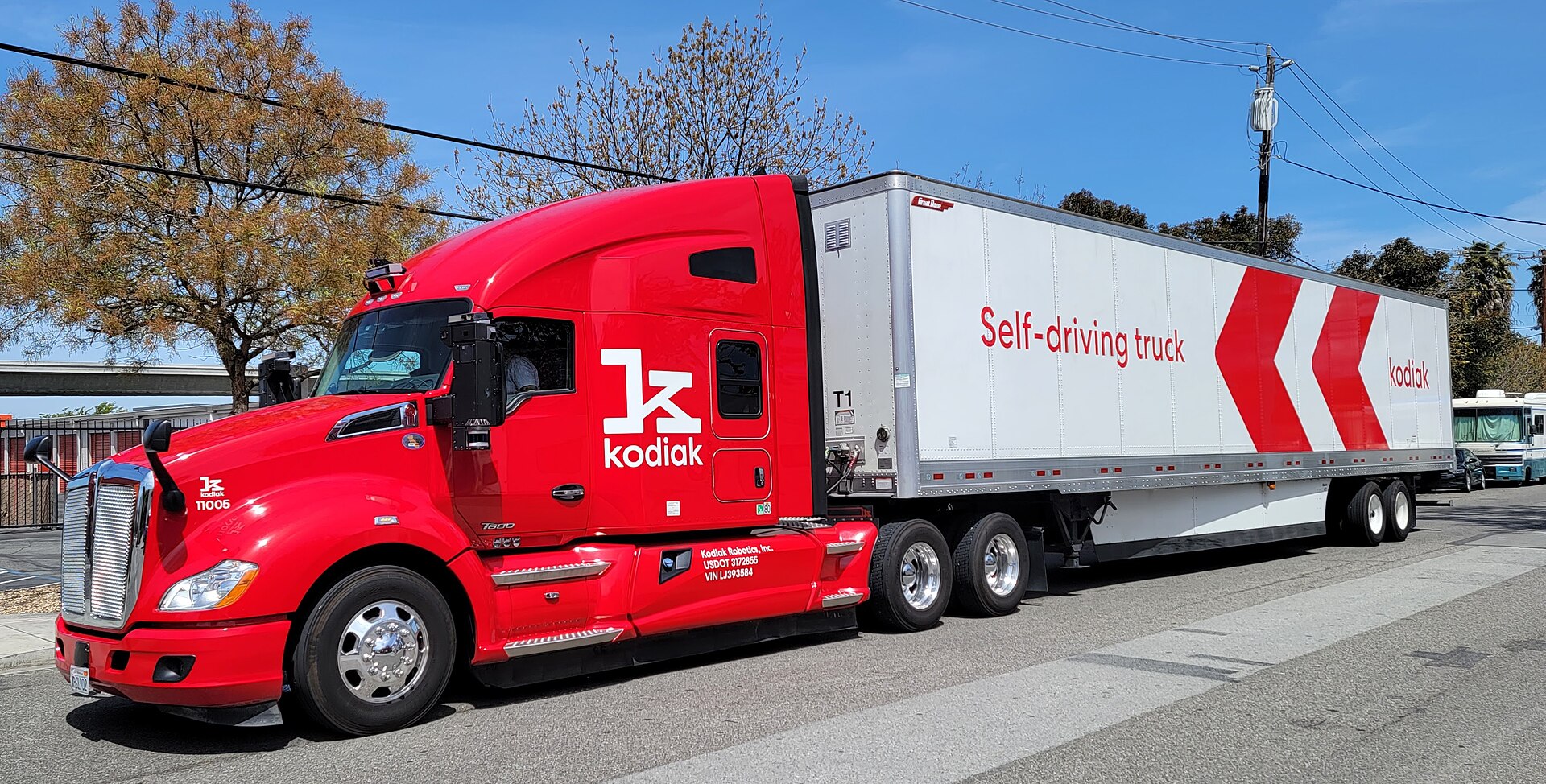 Autonomous Class 8 truck on highway at night, no driver visible in cab