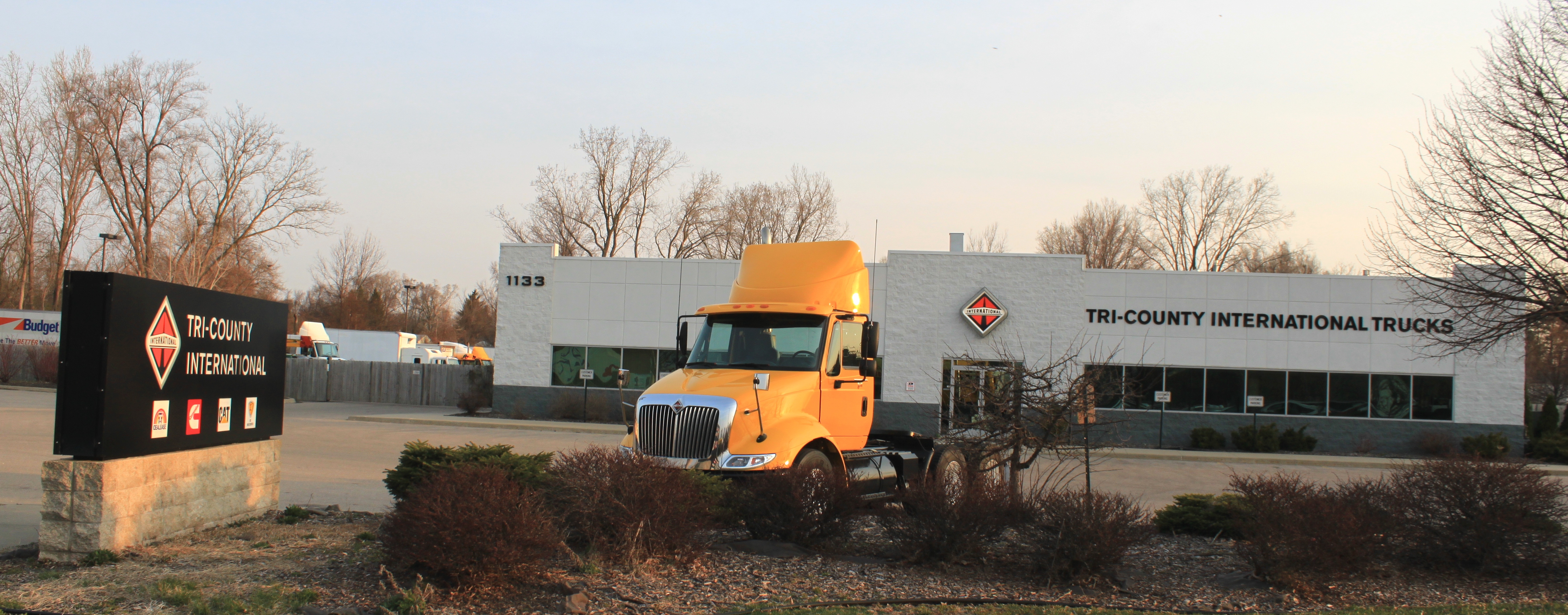 Exterior view of a modern truck dealership building with service bays and signage