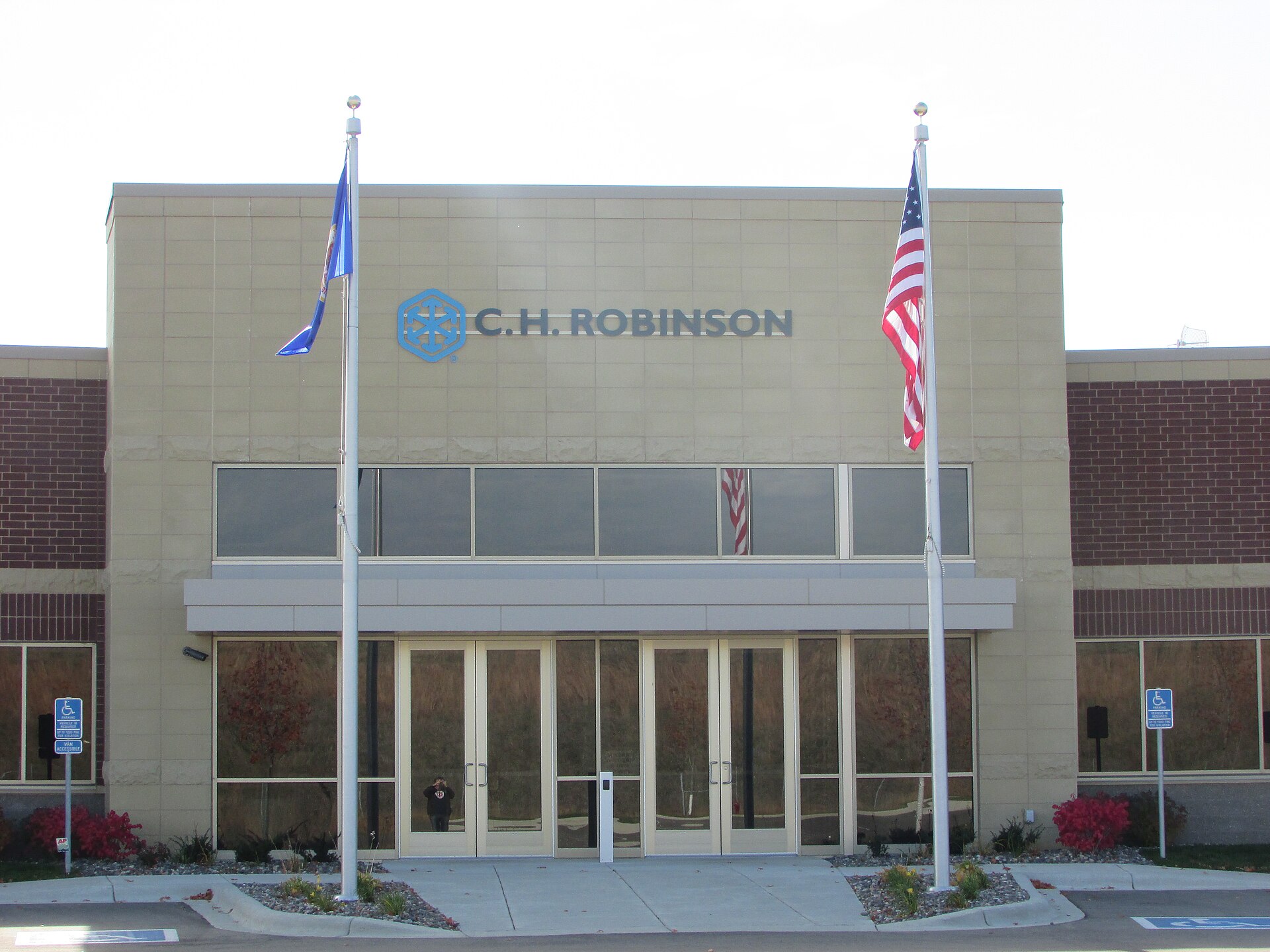 Freight broker office with computer screens showing carrier bids and shipper lane assignments