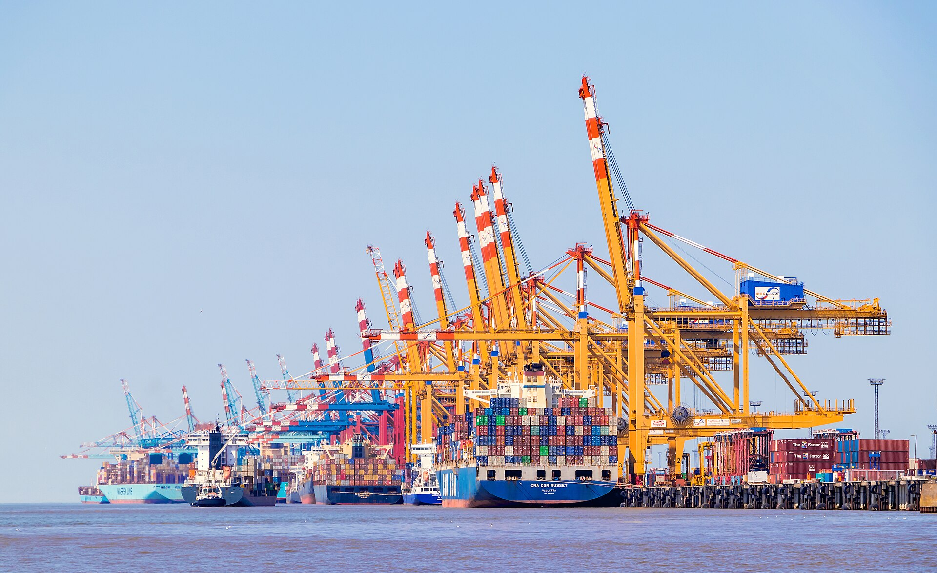 Container terminal with stacked shipping containers and drayage tractors at gate