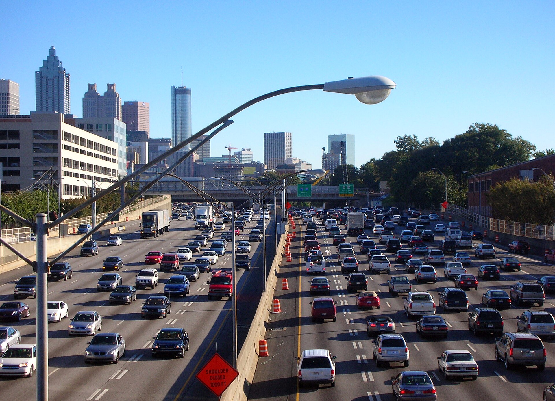 Heavy traffic congestion on interstate highway with commercial trucks stopped in multiple lanes during rush hour