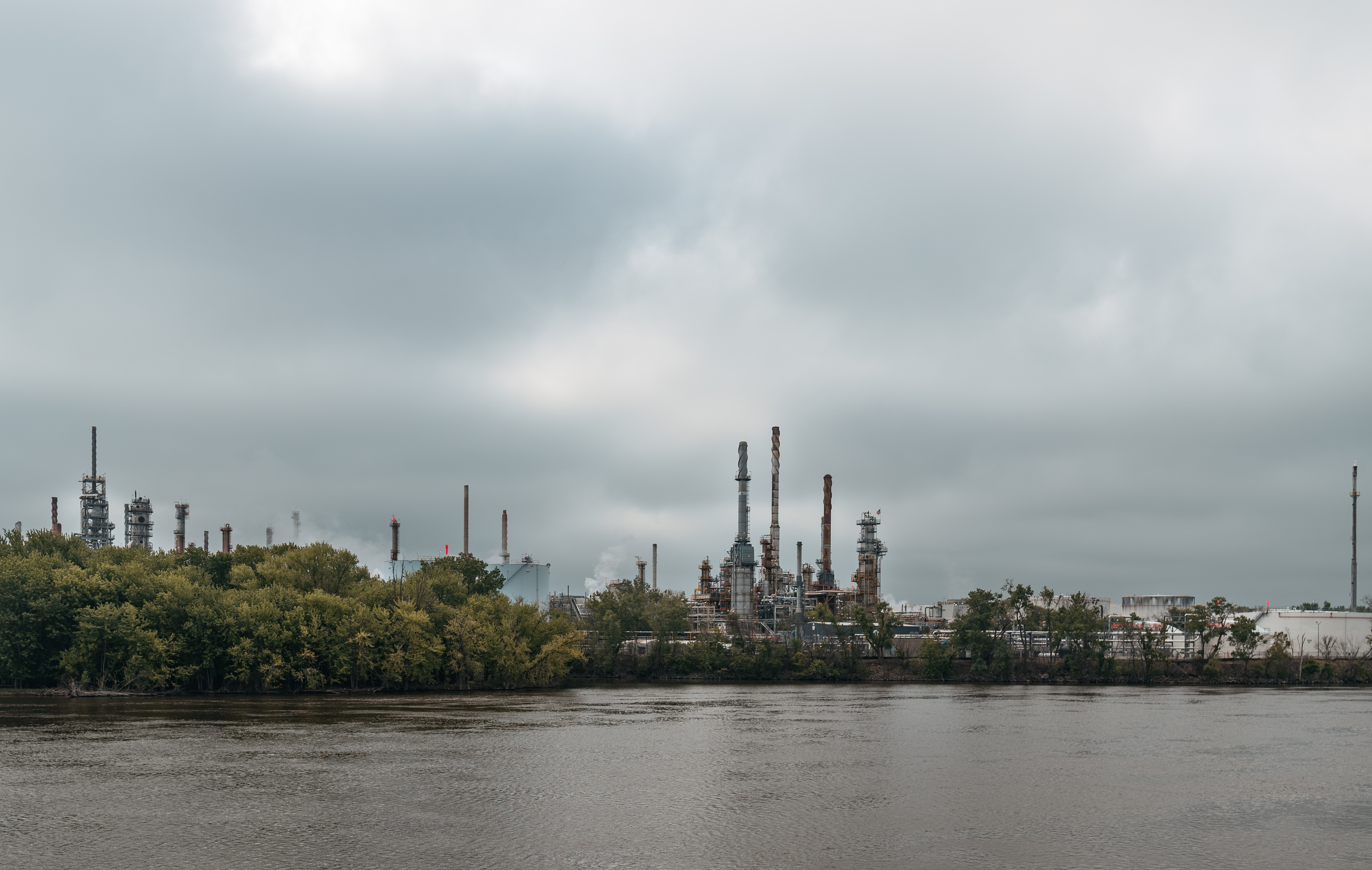 Oil barrels stacked at a refinery with price chart showing upward trend from $70 to $93 per barrel