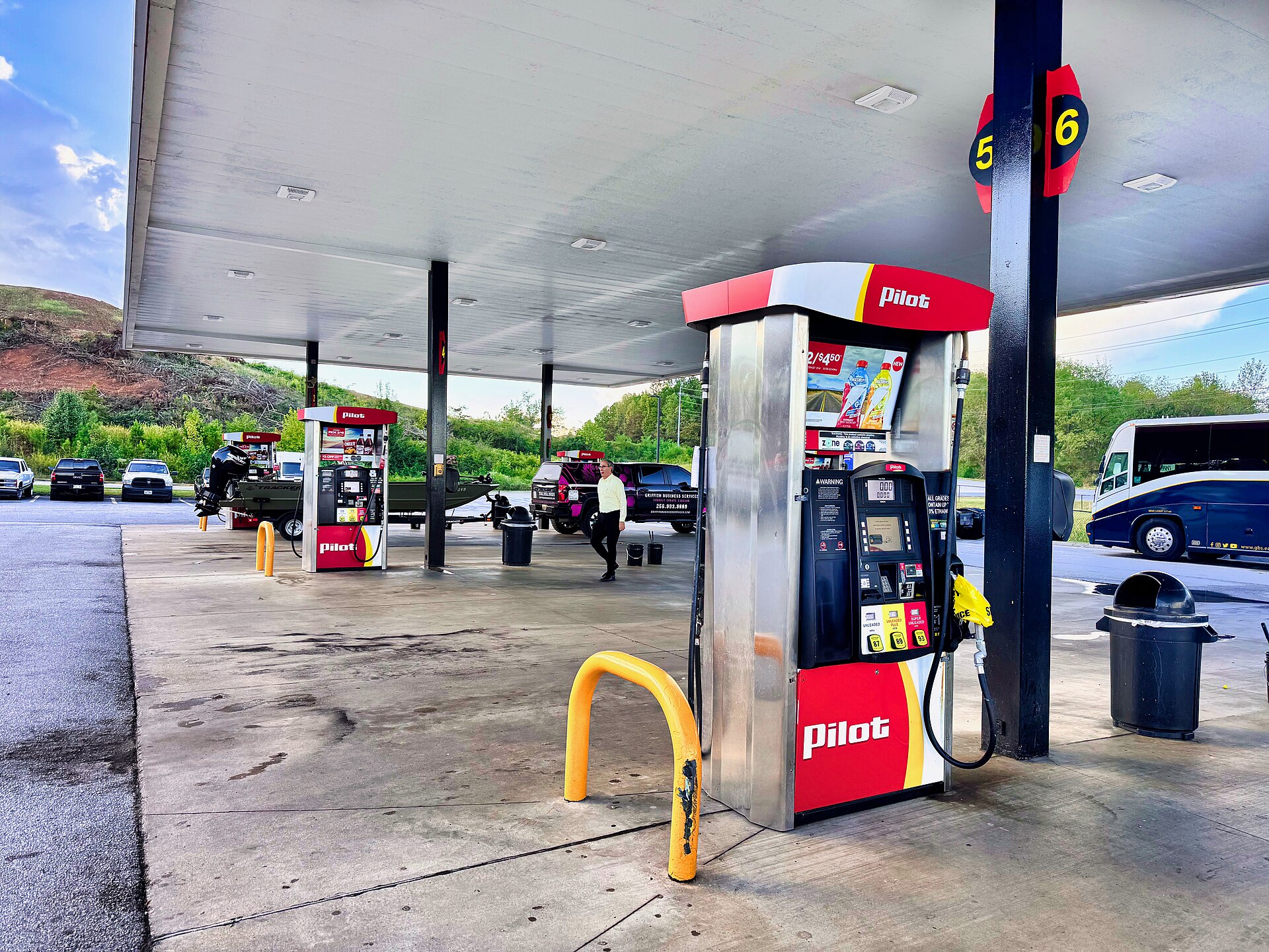 Fuel pump nozzle in gas tank with price display showing $4.48 per gallon