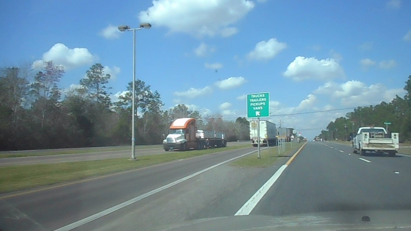 Commercial truck parked in remote lot with satellite view overlay showing unload location analysis