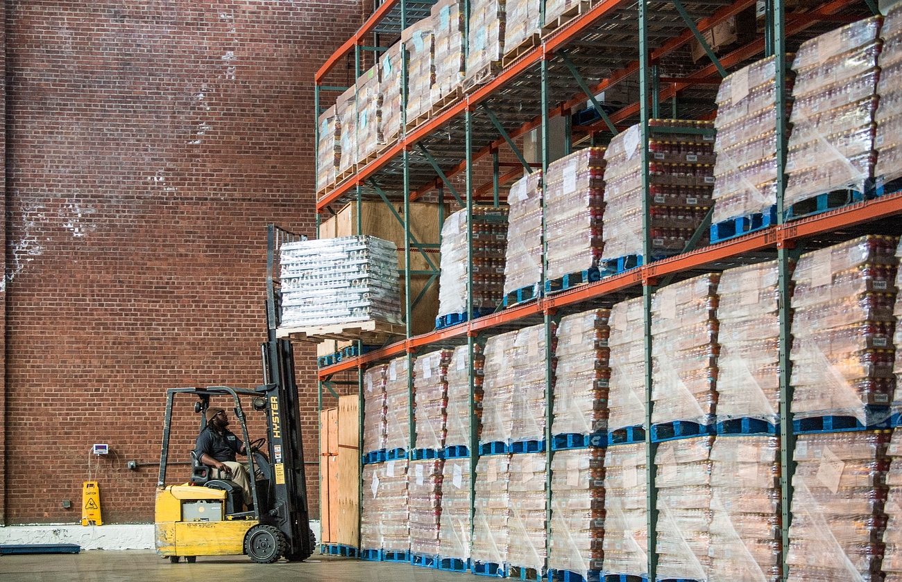 Warehouse workers loading freight pallets onto trucks at a distribution center