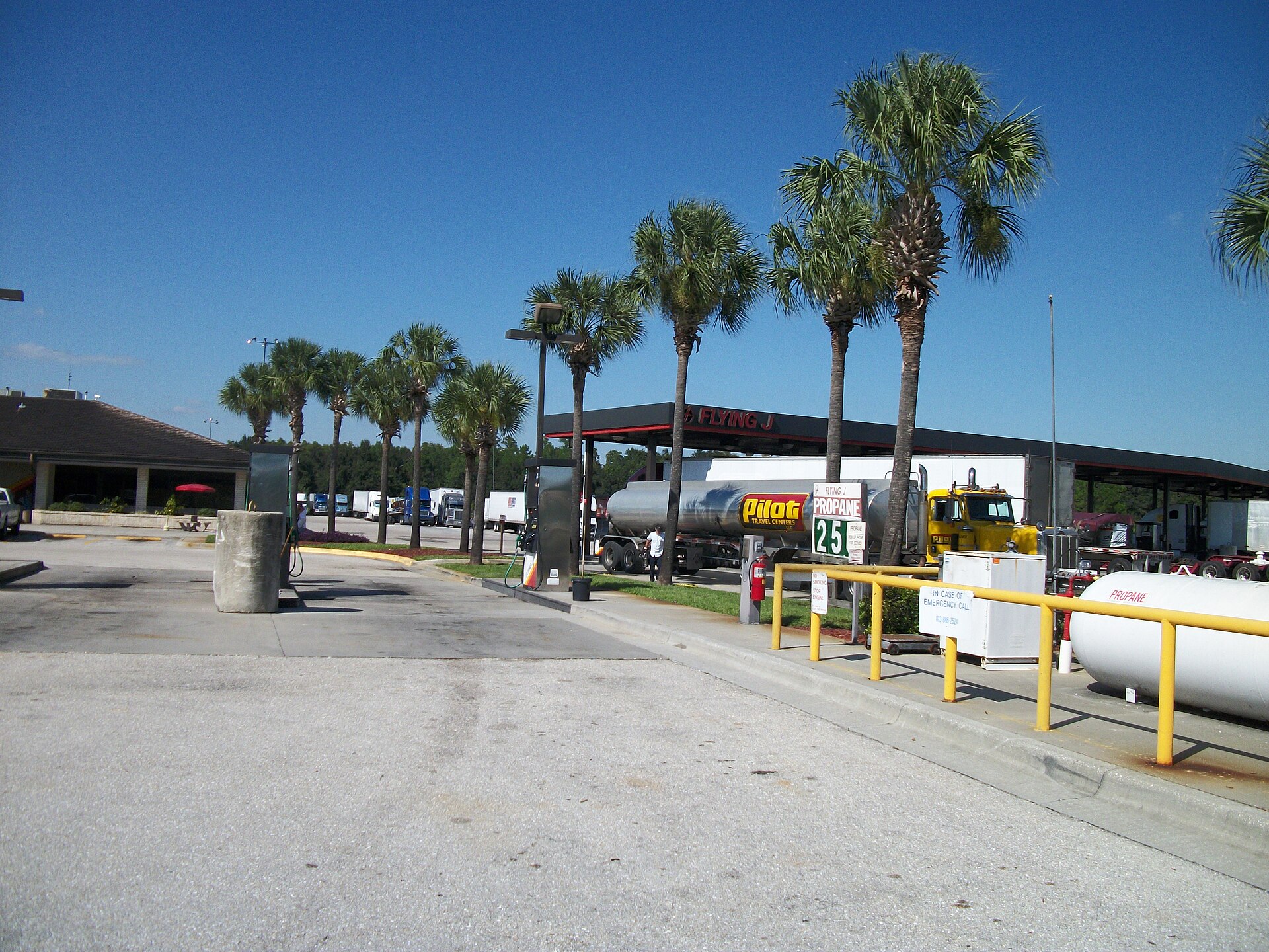 Propane fueling nozzle at commercial fleet fueling station with service trucks in background