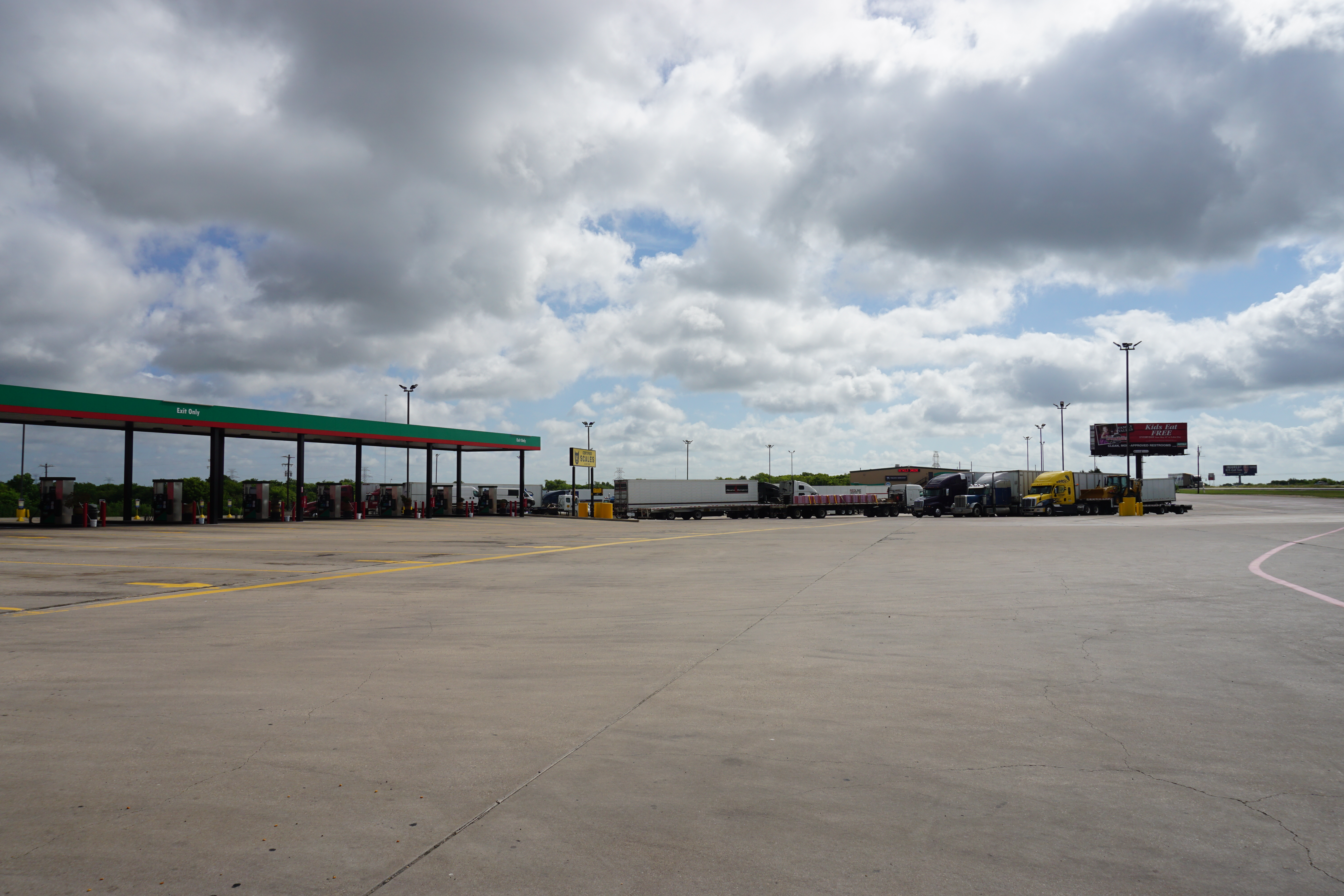 Semi-truck idling at rest stop with exhaust visible, illustrating fuel waste and emissions from extended engine idle time