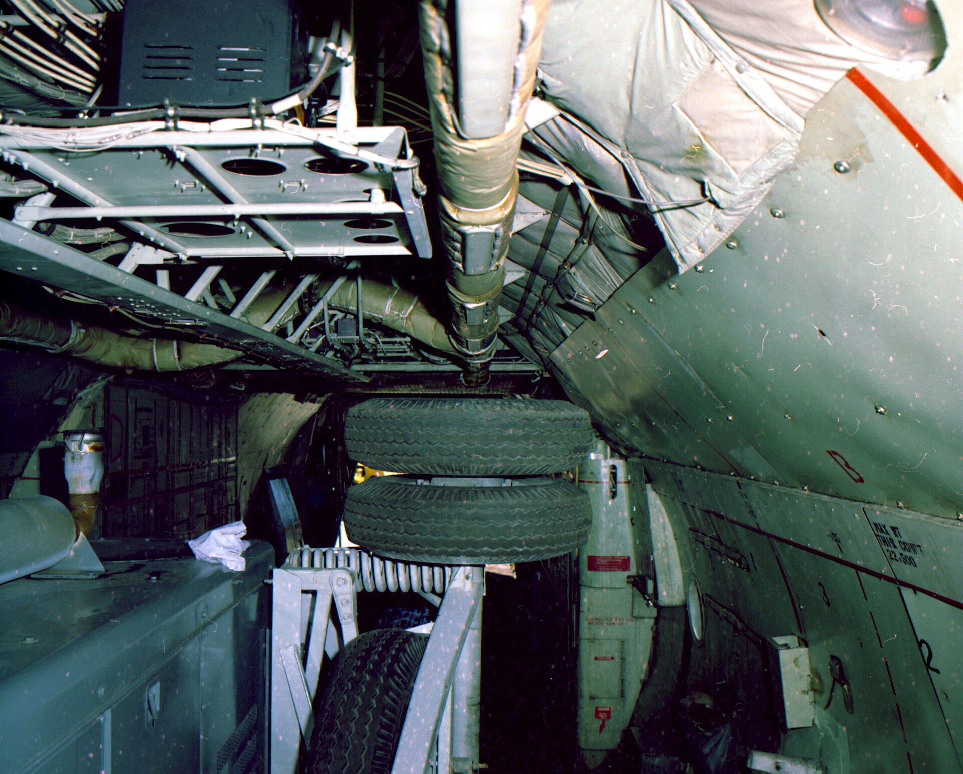 Commercial truck tire mounted on test wheel during FMVSS 119 endurance testing against rotating drum