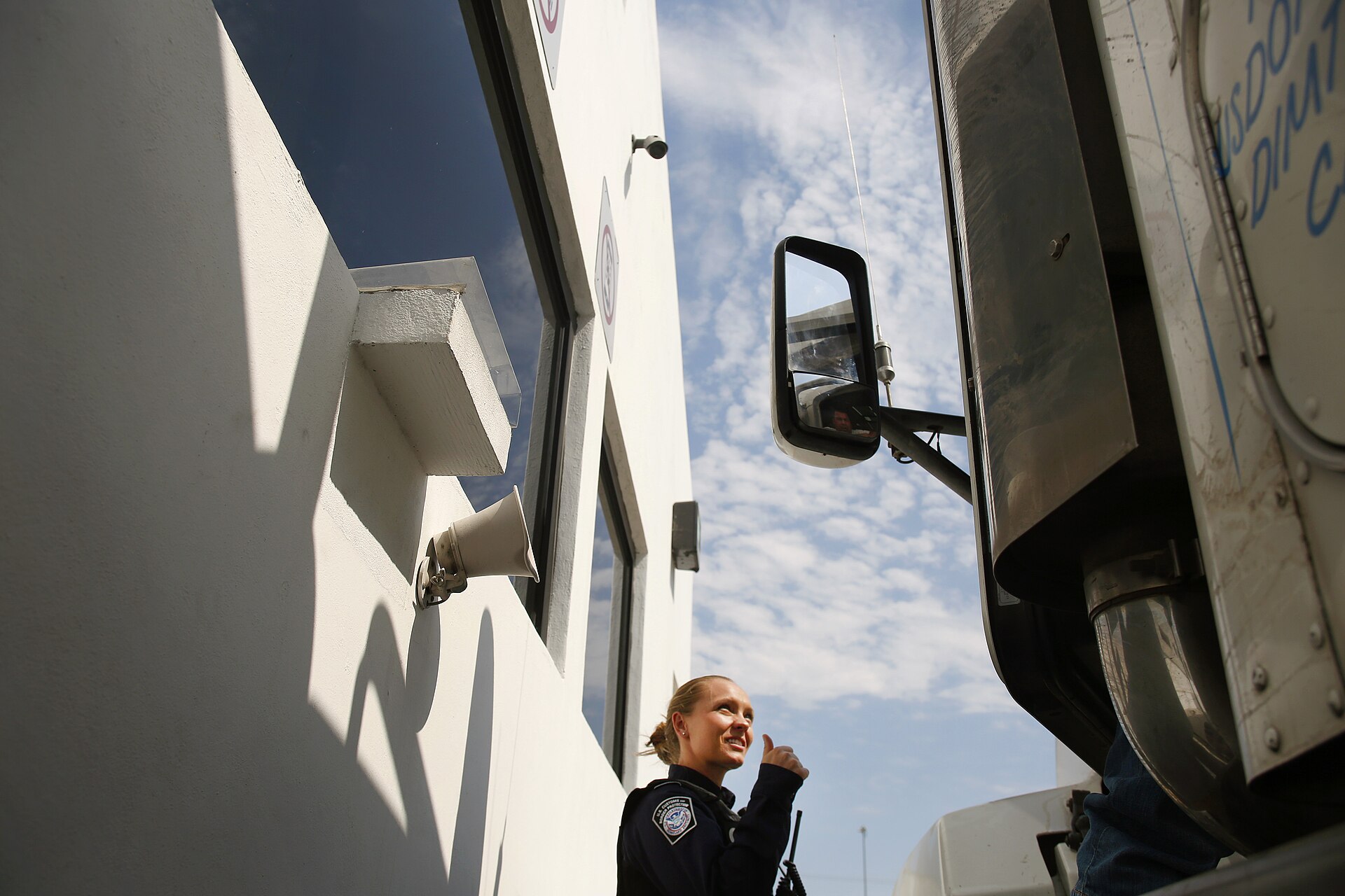 Customs and Border Protection officer inspecting commercial truck documents during roadside enforcement operation