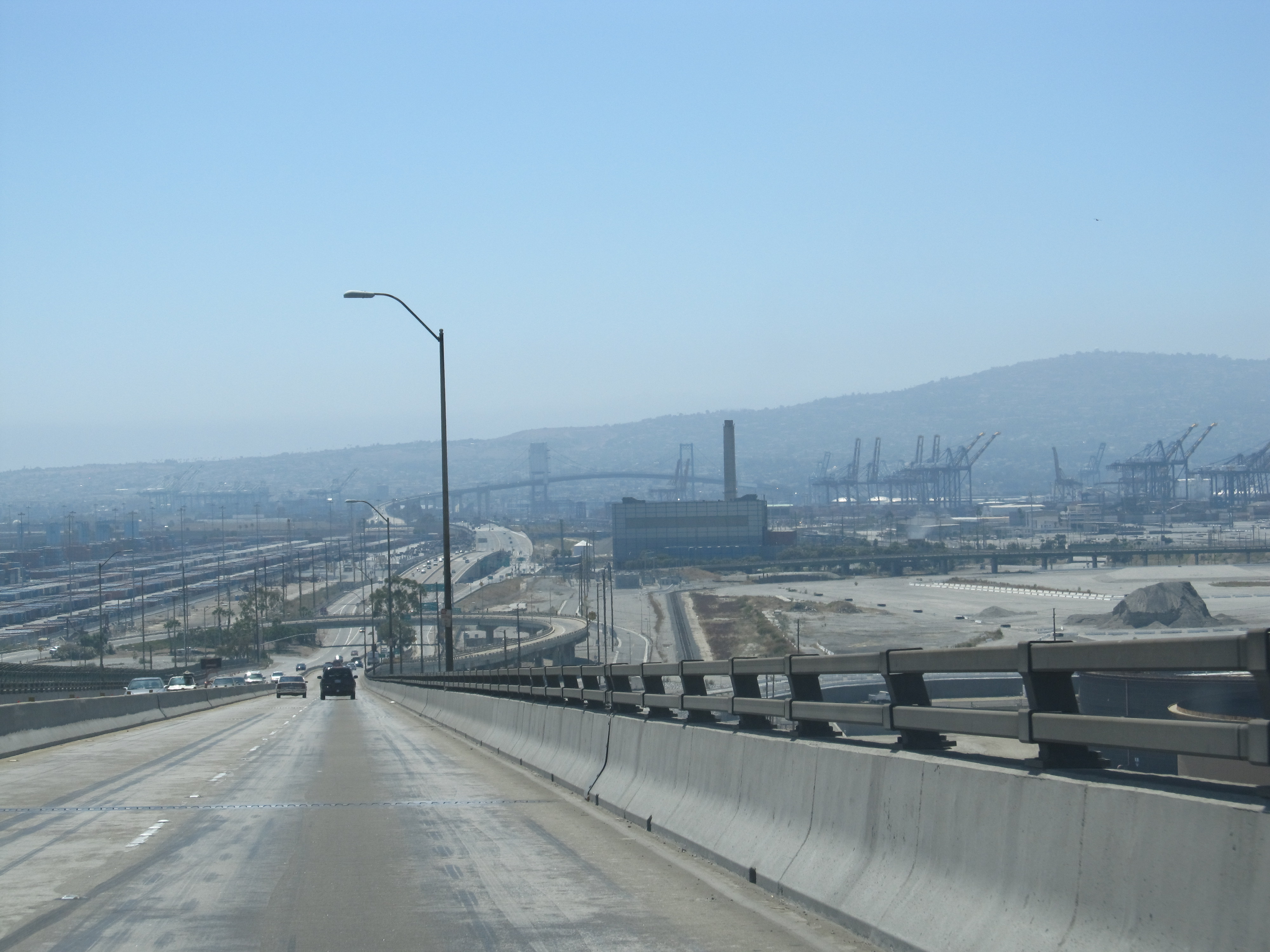 Container ships docked at Port of Los Angeles terminal with stacked shipping containers and cranes visible