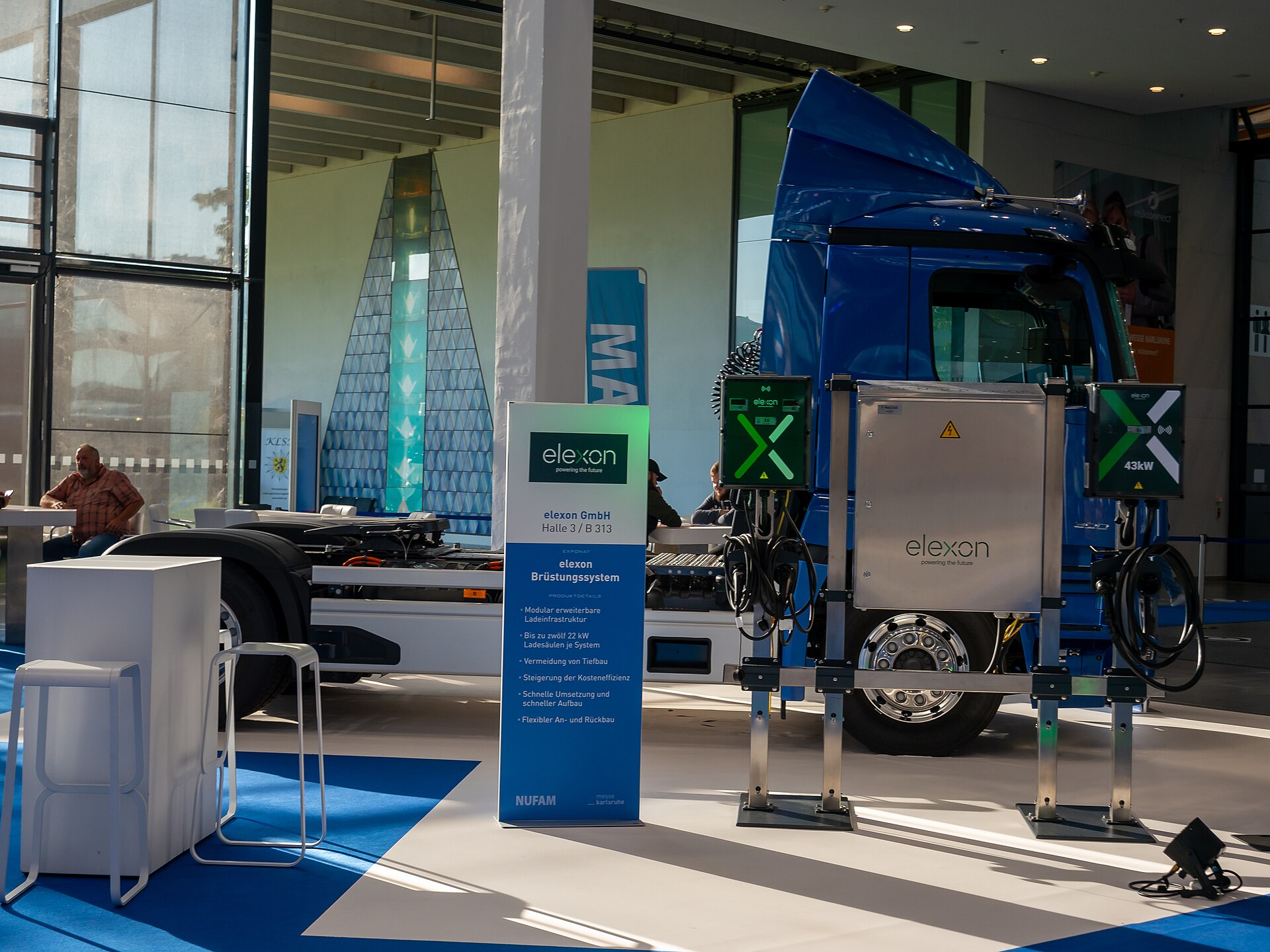 Electric Class 8 truck charging at commercial depot with overhead power infrastructure