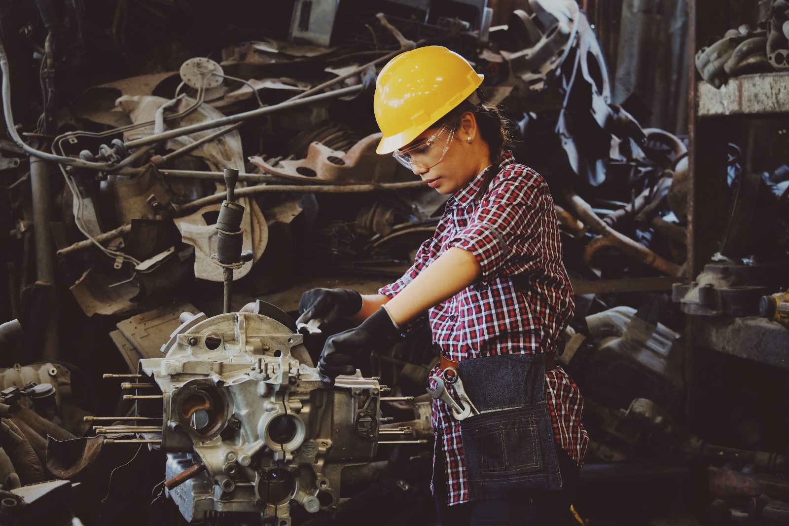 Semi-truck undergoing maintenance in a fleet repair shop with technician inspecting undercarriage
