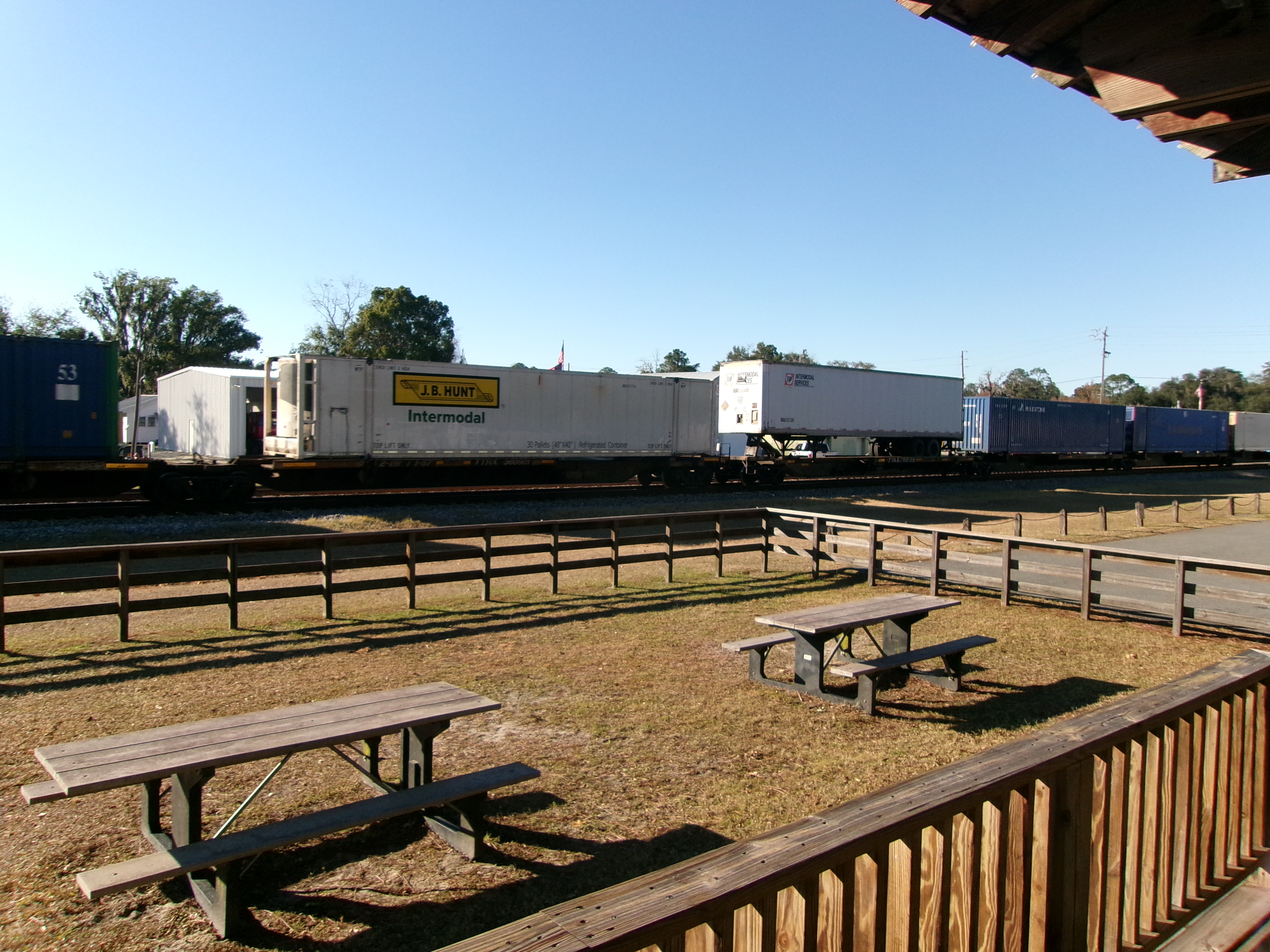 Red Peterbilt 589 long-hood tractor with custom lighting pulling a white refrigerated trailer