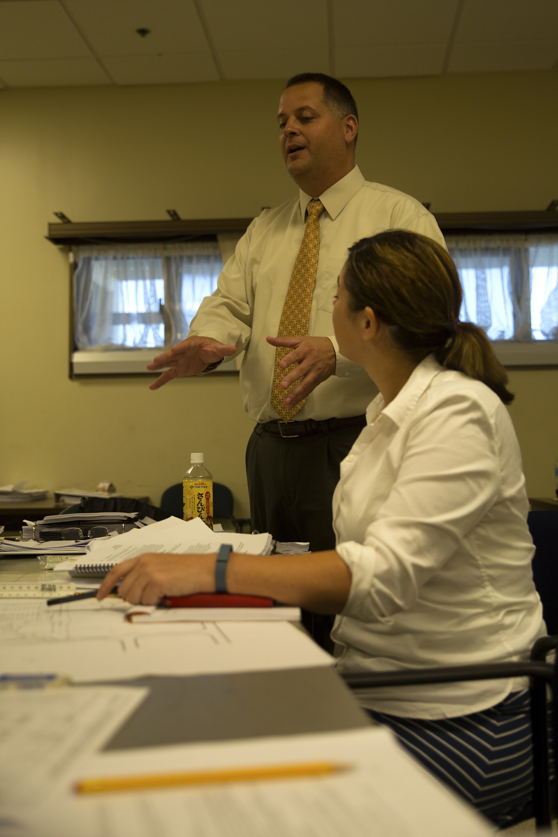 Compliance manager reviewing safety files and FMCSA audit documentation at desk in trucking fleet office